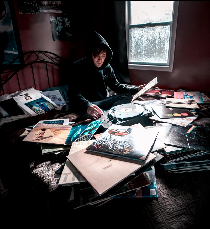 Man looking over stacks of music albums