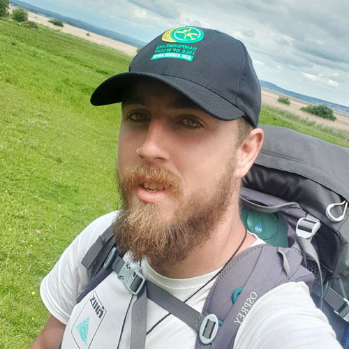 Photo of Joshua, with hat and backpack