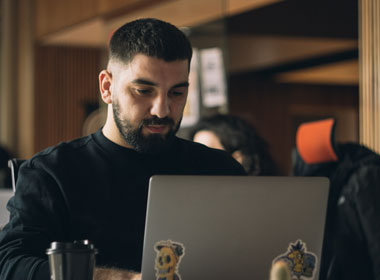 Man with beard sitting with laptop