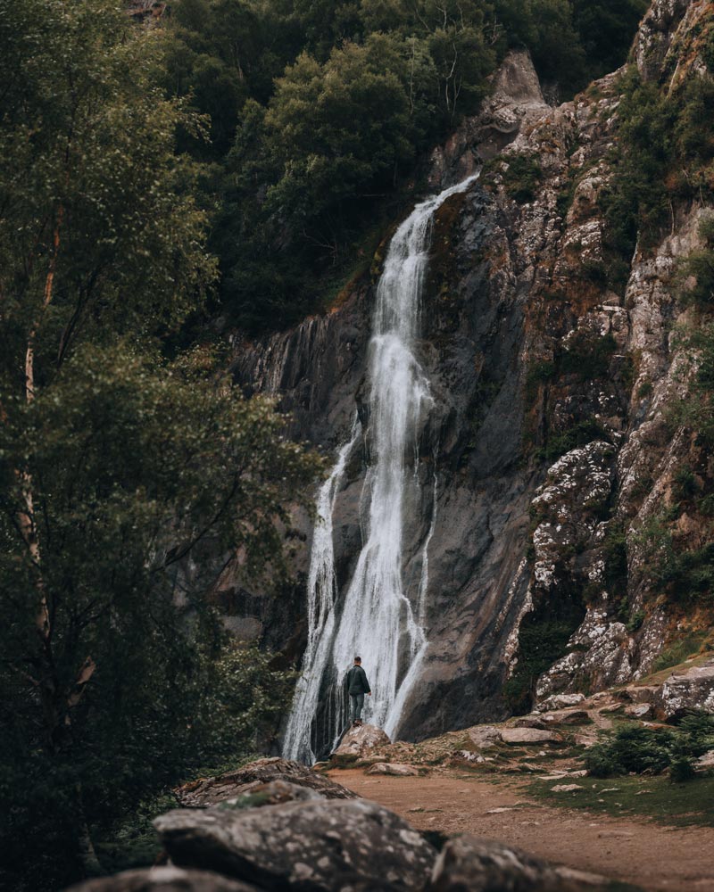 A man overlooks a large waterfall