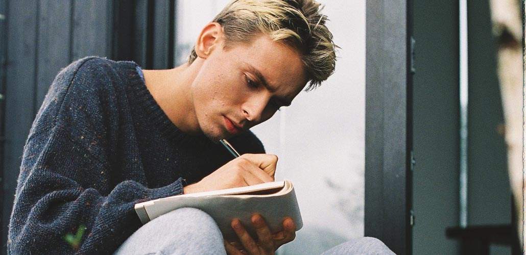 Man sitting and writing in journal